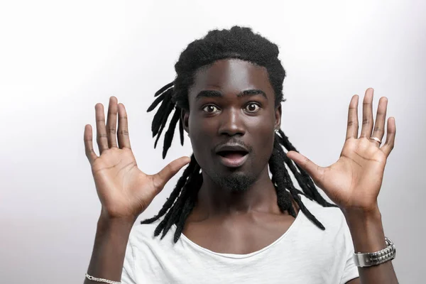 Geschokt Afro-Amerikaanse man draagt witte T-shirt kijken naar camera in verrassing — Stockfoto