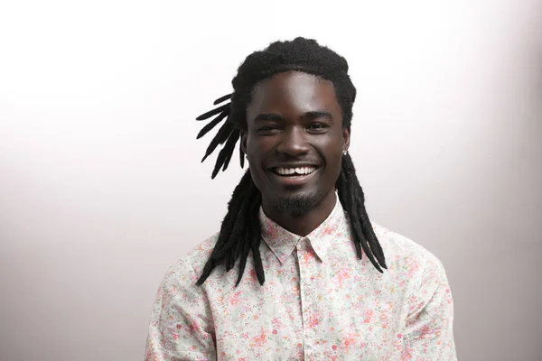 Feliz hombre afroamericano sonriendo aislado en el fondo blanco del estudio. Retrato de perfil masculino afroamericano — Foto de Stock