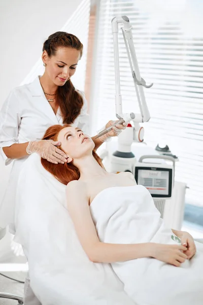 Mujer recibiendo tratamiento facial con láser en el centro médico, concepto de rejuvenecimiento de la piel — Foto de Stock