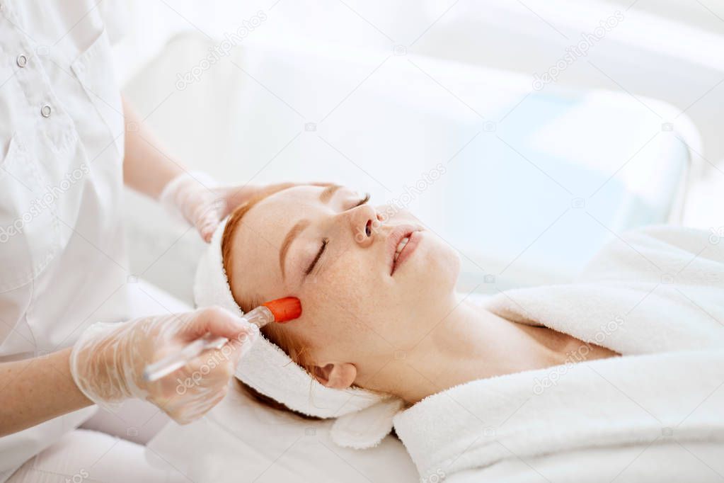 Doctor applies Hydro gel Mask on the woman before making laser treatment.