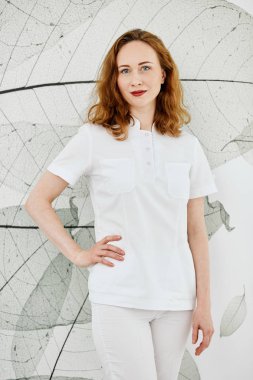 Kendine güvenen güzellik salonu kadın sahibi kameraya duvar arka plan üzerinde seyir.