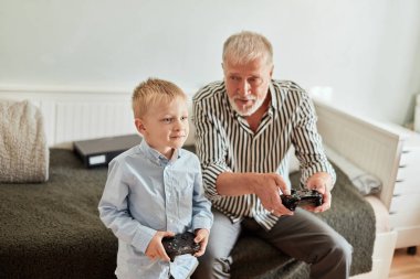 Dedem ve torunum bilgisayar başında joystick ile oyun oynuyorlar.