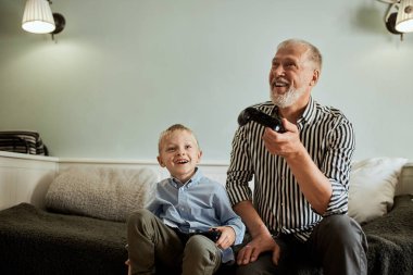 Dedem ve torunum bilgisayar başında joystick ile oyun oynuyorlar.