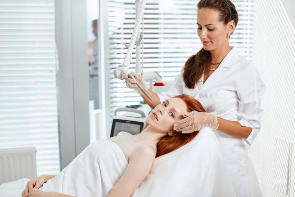 Mujer recibiendo tratamiento facial con láser en el centro médico, concepto de rejuvenecimiento de la piel — Foto de Stock