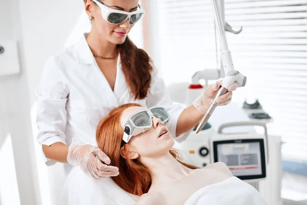 Kvinna får laser ansiktsbehandling i vårdcentral, hud föryngring koncept — Stockfoto