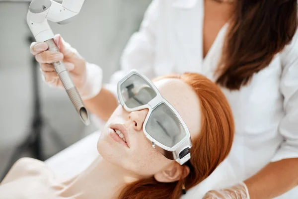 Mujer recibiendo tratamiento facial con láser en el centro médico, concepto de rejuvenecimiento de la piel — Foto de Stock