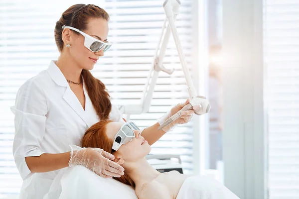 Mujer recibiendo tratamiento facial con láser en el centro médico, concepto de rejuvenecimiento de la piel — Foto de Stock