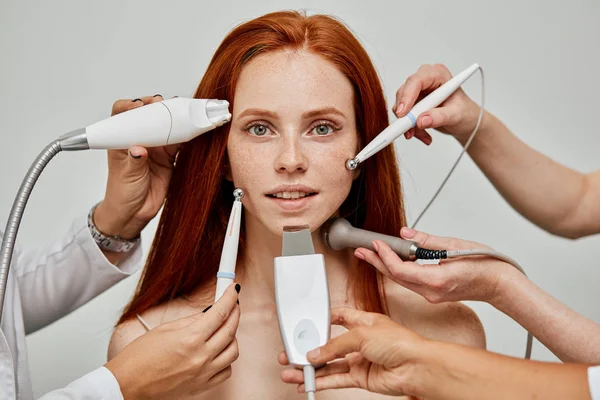 Konceptualny obraz kobiecej twarzy emocjonalnej i dłoni kosmetologa z urządzeniami — Zdjęcie stockowe