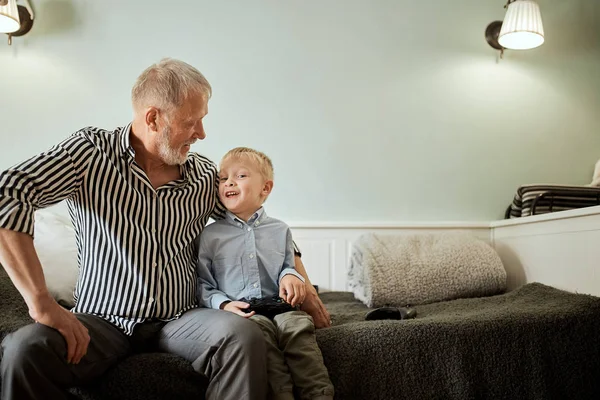 Pojke och hans morfar som spenderar tid tillsammans avkopplande på mysig soffa hemma — Stockfoto