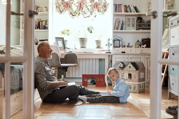 Abuelo se ve álbum de fotos con su boda, niño usando tableta electrónica — Foto de Stock