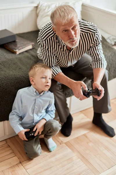 Dziadek i wnuk grają w gry wideo na komputerze z joystickiem — Zdjęcie stockowe