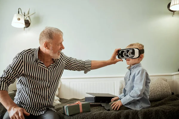 Niño y su abuelo usando gafas vr en el sofá en casa — Foto de Stock