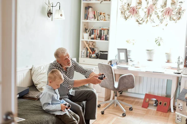Grandfather and grandson playing video games on computer with joystick — Stock Photo, Image
