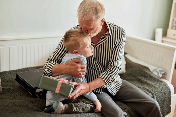 Generation. farfar och sonson med presentförpackning sittandes på soffan hemma — Stockfoto