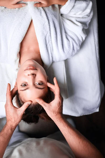 Mulher desfrutando de massagem facial anti envelhecimento. De cabeça para baixo foto de mulher relaxante — Fotografia de Stock