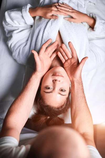 Женщине нравится антивозрастной массаж лица. Перевернутое фото расслабляющей женщины — стоковое фото
