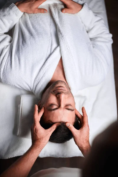 Ung man som får massage på spa salong, ovanifrån — Stockfoto