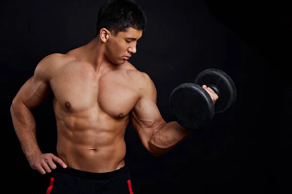 Strong muscular guy is training with dumbbel at gym — Stock Photo, Image