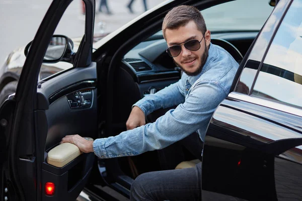 Schöner prächtiger Mann öffnet die Tür seines neuen Autos — Stockfoto