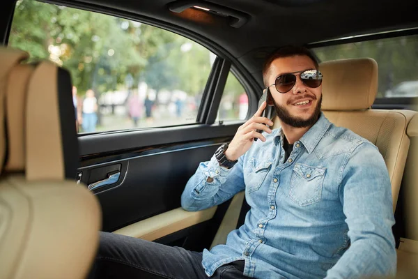 Positiver bärtiger Mann spricht während des Autofahrens mit seiner Freundin — Stockfoto