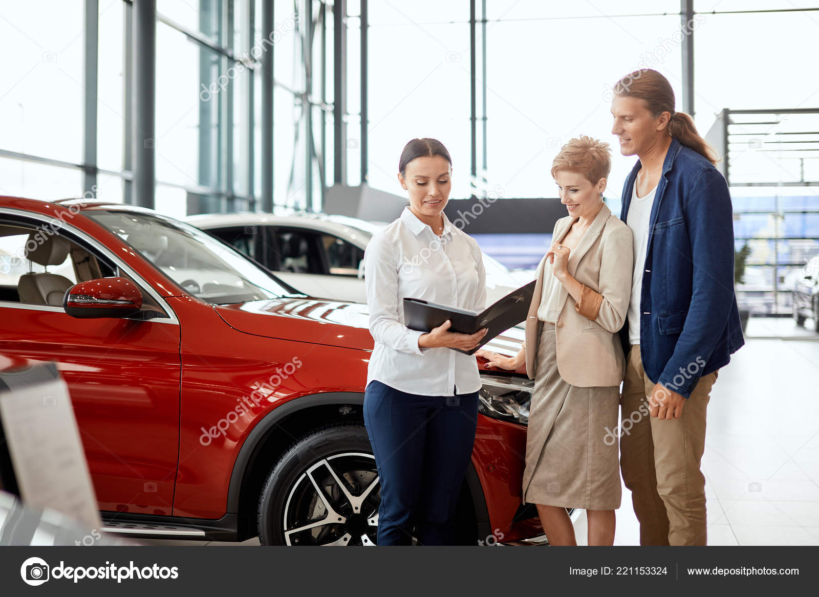 Car sales manager telling about the features of the car to the