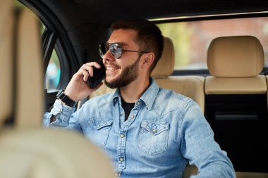 Genç iyi görünümlü adam telefonda konuşurken zevk