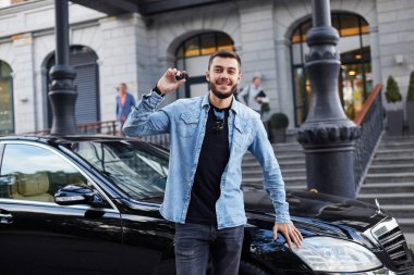 Siyah araba önünde duran ve sunma yakışıklı adam