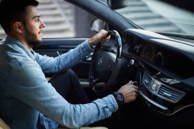 attractive driver is turning on the vehicle