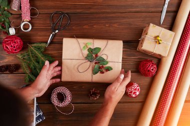 Kadın hediye paketi ve ahşap masa üzerindeki dekorasyon malzemeleri, yakın, üst görünüm.