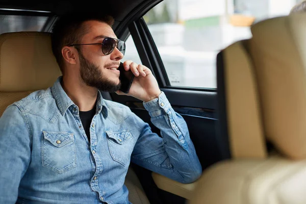 Geschäftsmann mit Handy im Auto — Stockfoto