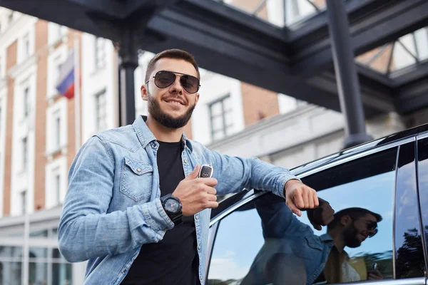 positive man is closing his car on alarm system