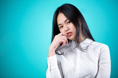 Güzel genç Asyalı kadın mavi arka planda izole edilmiş. Yüz Yüzü 