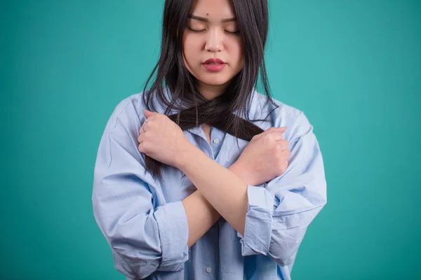 Приваблива азіатська жінка позує ізольовано на синьому фоні — стокове фото