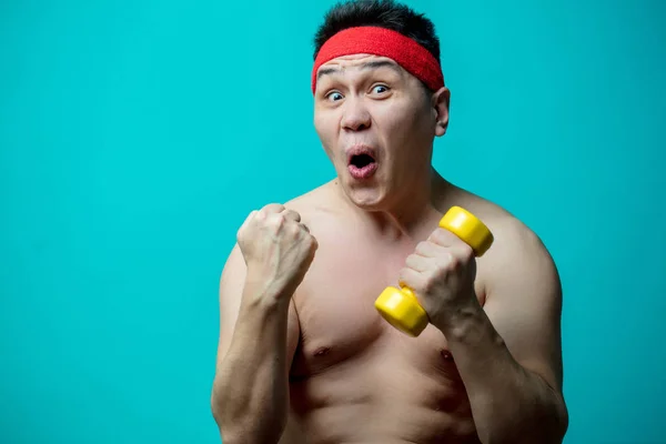 Asiático emocional hombre con desnudo torso ejercicio con dumbbells —  Fotos de Stock