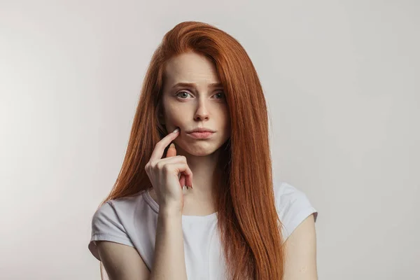 Porträt der unzufriedenen attraktiven rothaarigen Frau isoliert über weißem Hintergrund — Stockfoto