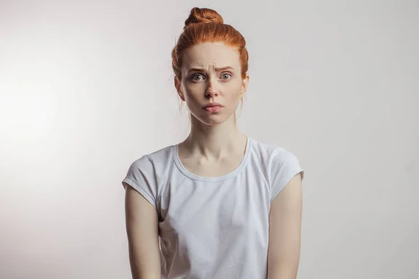 Redhead girl with hair bun and freckles isolated over grey background — Stock Photo, Image