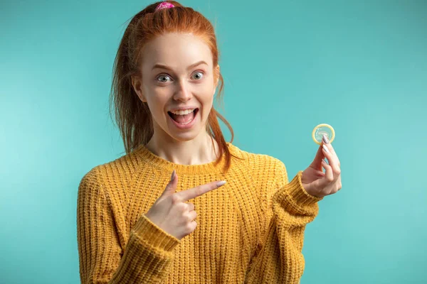 Woman holding condom, prevention of sexually transmitted disease — Stock Photo, Image