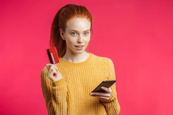 Retrato de linda chica de jengibre usando teléfono inteligente aislado sobre fondo rosa —  Fotos de Stock