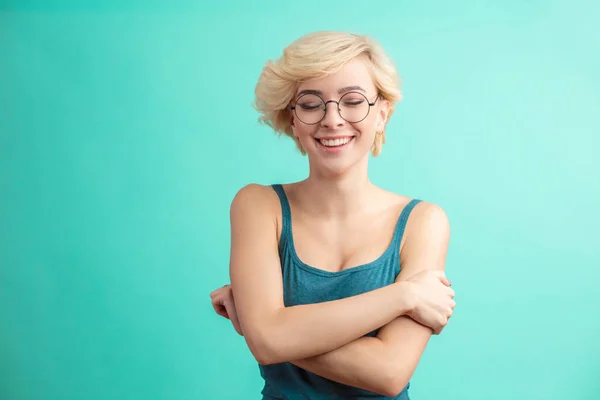 Hermosa mujer joven rubia mirando a la cámara abrazándose. — Foto de Stock