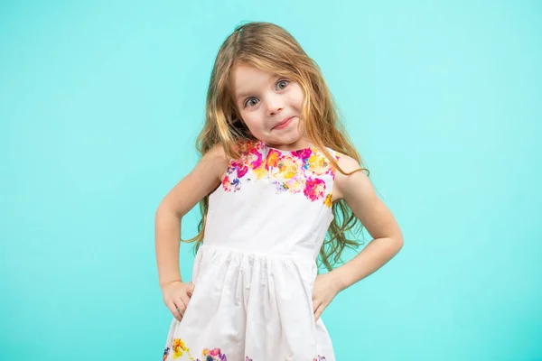 Linda niña pequeña con un vestido de verano de flores aislado en azul —  Fotos de Stock