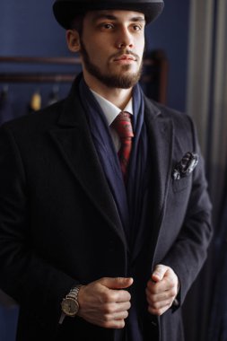 Karanlık kat ve trendy elbise kapalı çekici bir adam portresi terziler