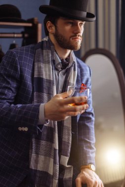 Moda bir takim elbisesi ve içecek ile atelier, poz zarif erkekte