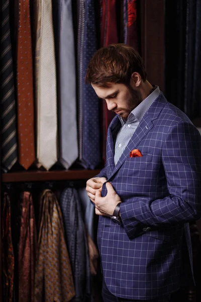 Young bearded businessman trying on custom tailored suit, buttoning jacket — Stock Photo, Image