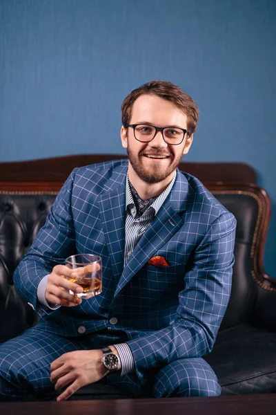 Handsome young man in a classic suit drinking red wine in restaurant