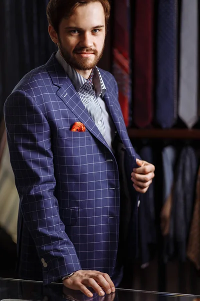 Hombre elegante en traje de moda y sombrero posando en el taller con bebida — Foto de Stock