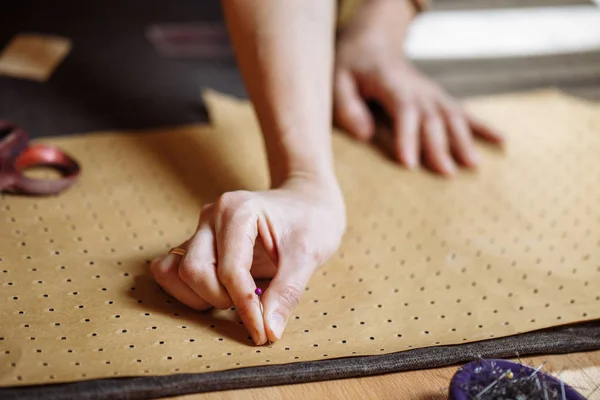 Alfaiate furando um pino para o padrão de pano na costura oficina fêmea — Fotografia de Stock