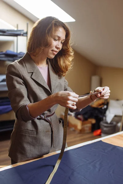 Dressmaker mujer trabajando con cinta métrica en atelier —  Fotos de Stock