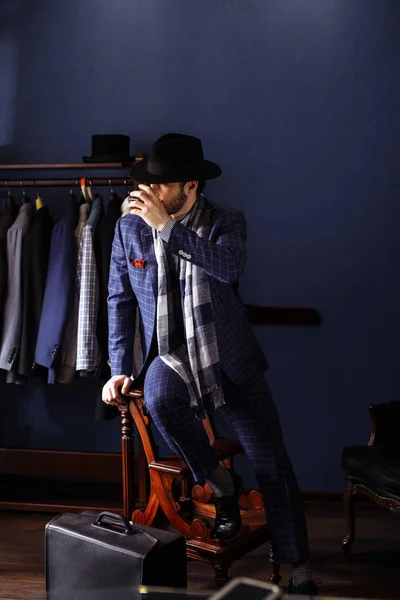 Elegante man in mode pak en hoed poseren bij atelier met drank — Stockfoto