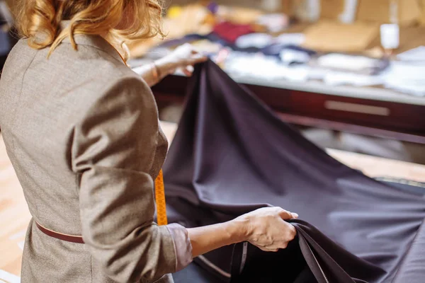 Kadın Moda Tasarımcısı tablo terzilik aksesuarları ile kumaş elbise kumaşı üzerinde çalışma — Stok fotoğraf