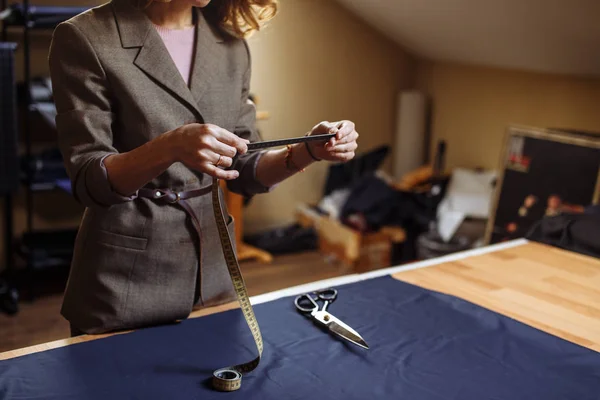 Дресмейкер жінка працює з вимірювальною стрічкою в ательє — стокове фото